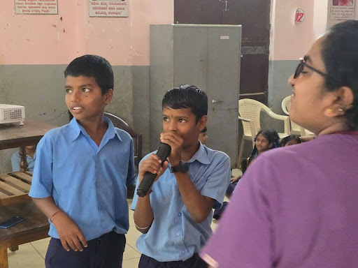 A young student takes the mic and actively participating in the 'Healthy Hero' awareness session at a Mangalore Government School.
